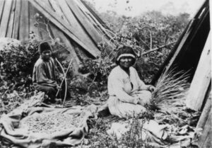 A Native American woman and boy sitting on the ground