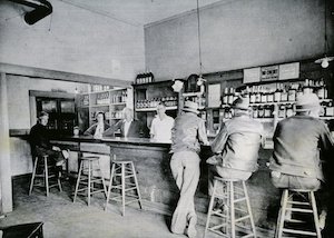 People standing and sitting at a bar