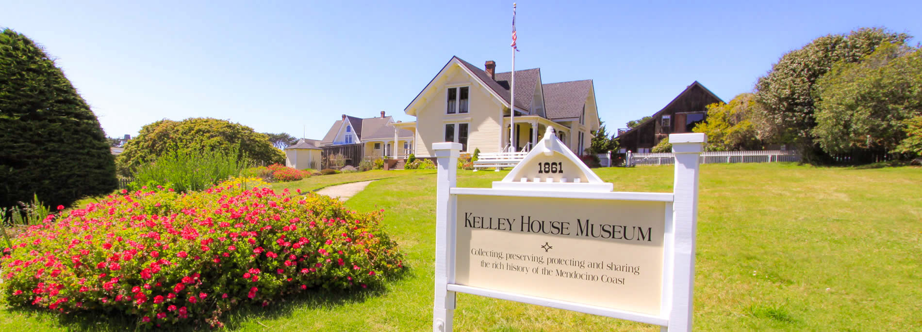 sign with yard and home @ kelley house museum mendocino california
