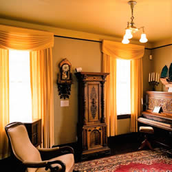 antique chair and piano in kelley house museum