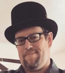 man with glasses wearing a top hat