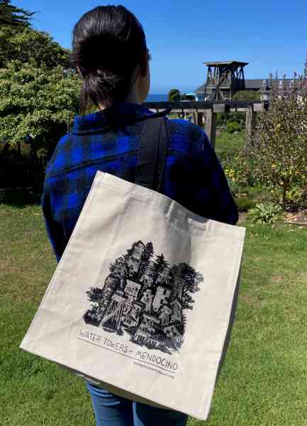woman holding tote bag looking at a water tower