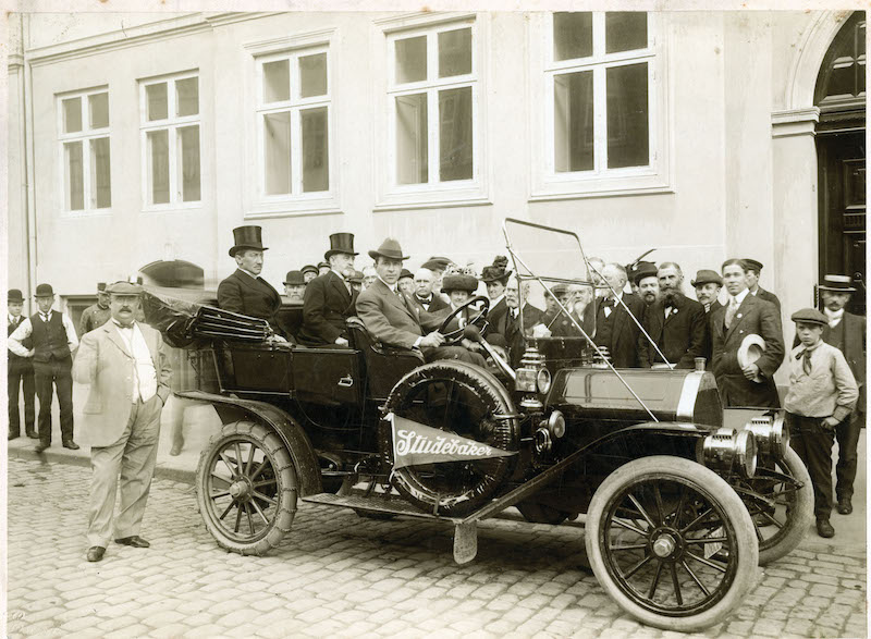 People seated in an antique Studebaker automobile