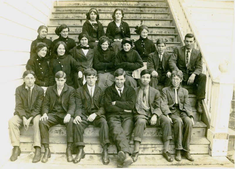Teenagers sitting on steps looking at camera