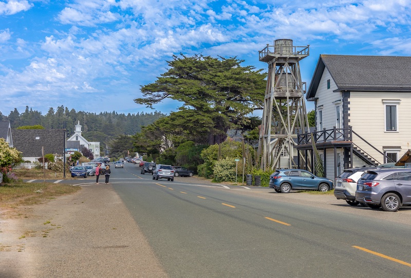 View of a paved street with historic buildings and a water tower