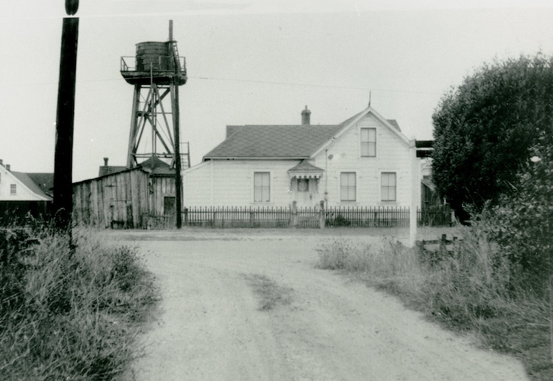 Black and white photo of historic house and water tower