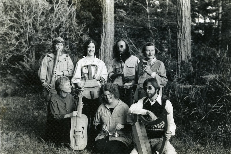 Musicians facing camera holding instruments