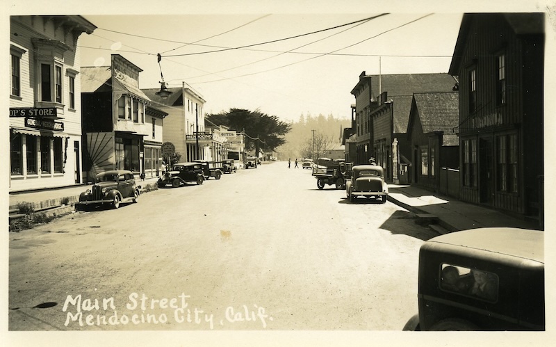 View down an unpaved street lined with historic buildings