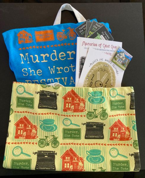 tote bag with designs holding a t-shirt, card, and book