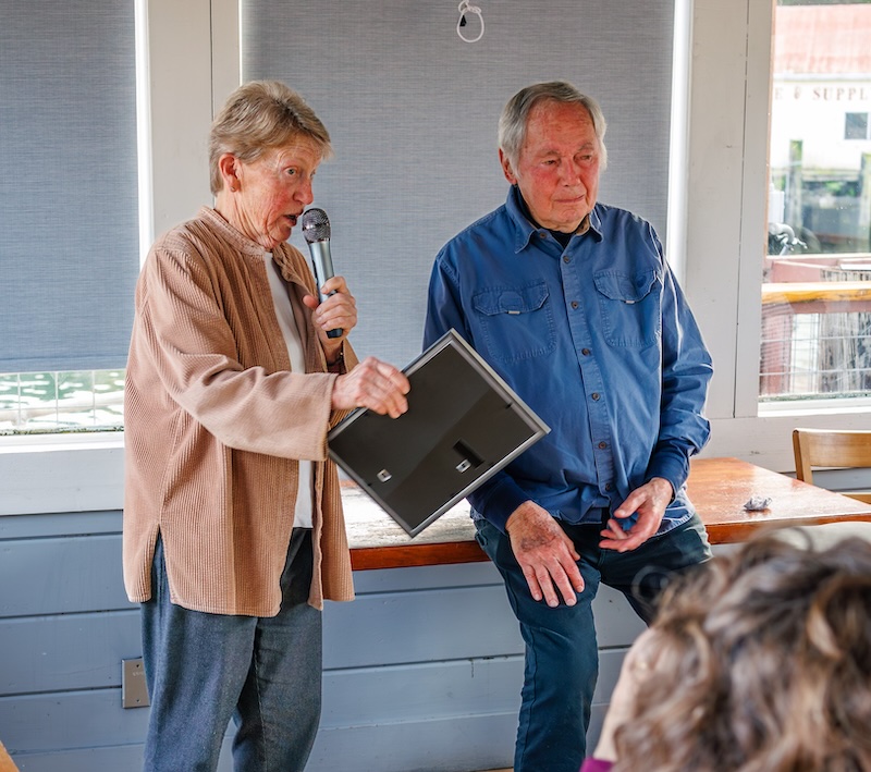 Woman with microphone speaks while standing next to man