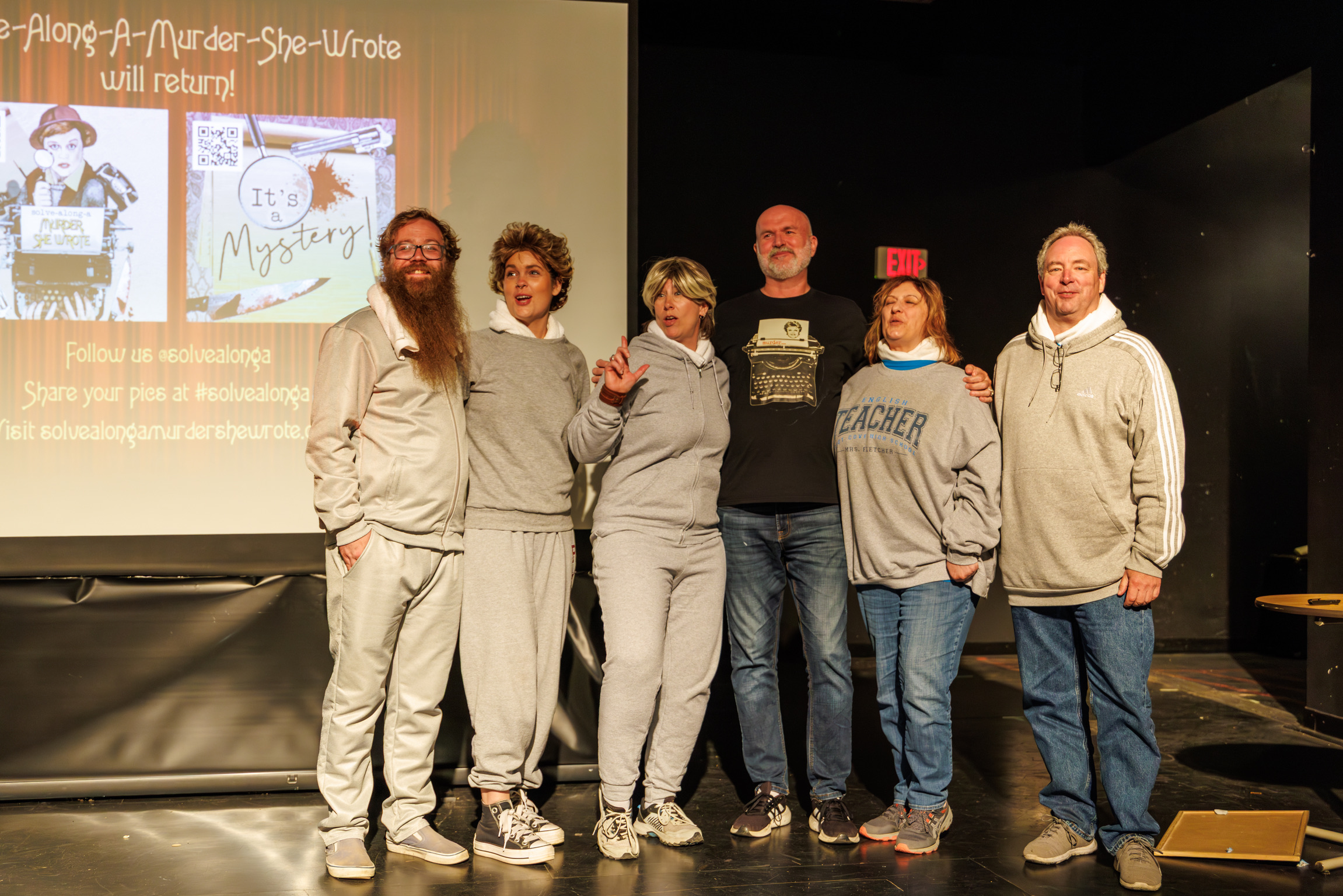 people on a stage dressed in gray track suits