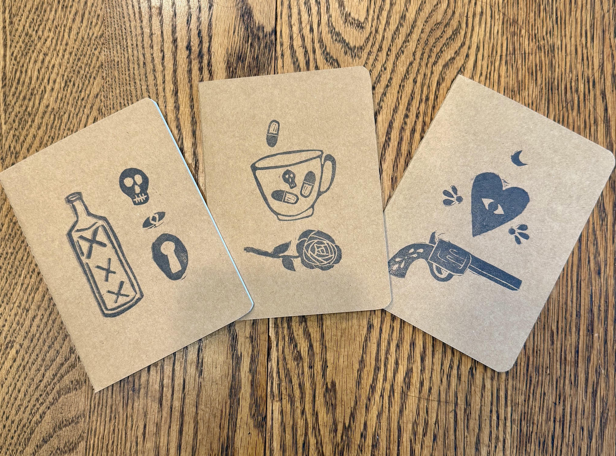 three brown books with different stamped images on cover
