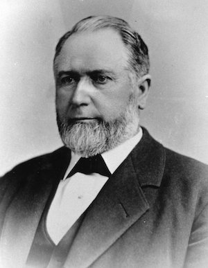 A portrait of a bearded older man in a suit