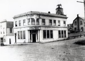 A large two-story building on a street corner with the door facing the corner