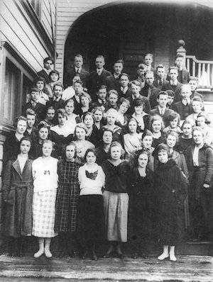 A large group of young men and women posing on stairs outside of a building