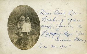 An oval portrait of two young children with handwritten note dated to December 30, 1915 saying "Happy New Year"  beside the photo
