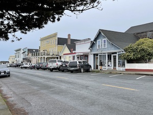 Colorful buildings line a street with cars parked in front of them