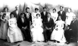 A group of well-dressed young men and women with their teachers