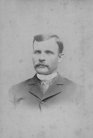 Studio portrait of a mustached Victorian man in a suit
