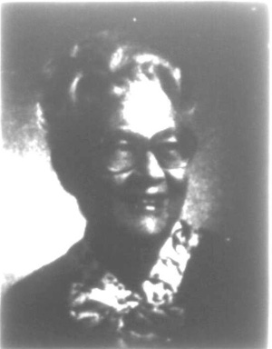 Studio photo of a smiling older woman with glasses