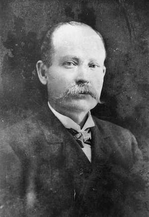 Studio portrait of a man in a suit with a mustache