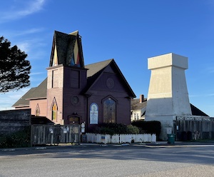 Church building with steeple next to a water tower
