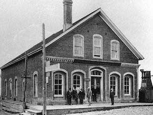 Men standing in front of a large brick building