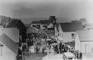 Elevated view of a procession of people on a street lined with houses