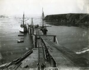 Large boats docked at a wooden wharf