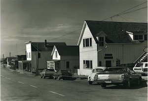 Street lined with buildings and old cars