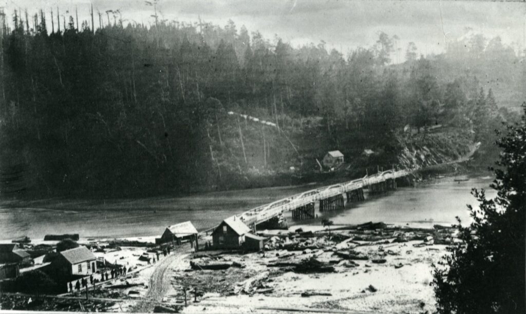 Bridge over a river with trees in the background and buildings in the foreground