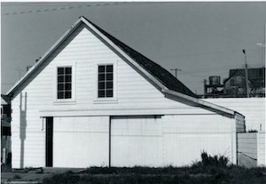 The former Eugene Brown store/barn, before reconstruction. Note the boardwalk in front. The water tower and rooftop on the right belong to the Paoli Hotel. To the right is a retaining wall associated with the Eugene Brown House.