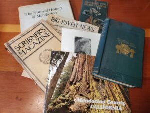 Old books and magazines about Mendocino laying on a table