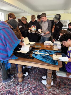 Students gathered around a table with historical artifacts