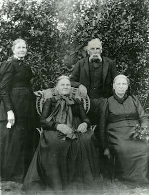 Three elderly women and an elderly man in front of trees