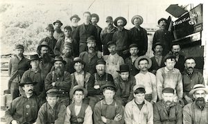 Crew of male mill workers facing camera