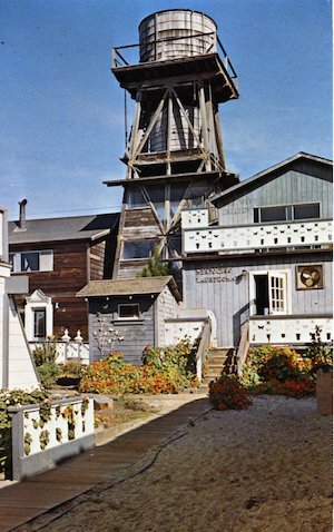 Two-tank water tower between two buildings