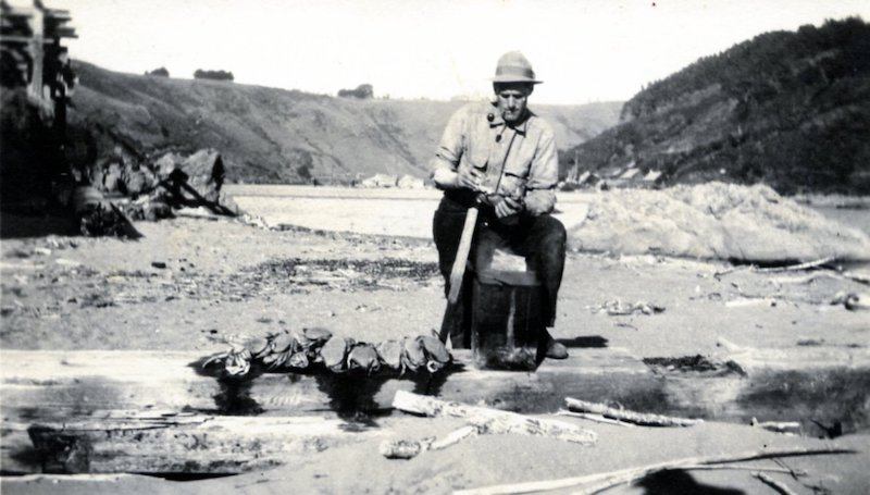 Man cleaning crabs on beach