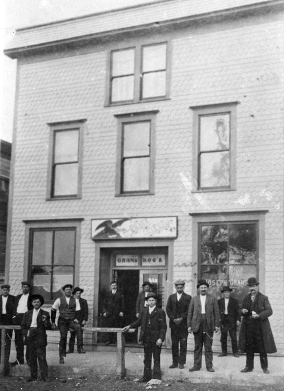 Two-story saloon building with men standing out front