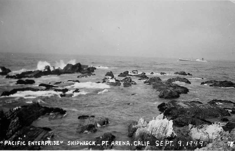 Ship sinking with rocky shore in foreground